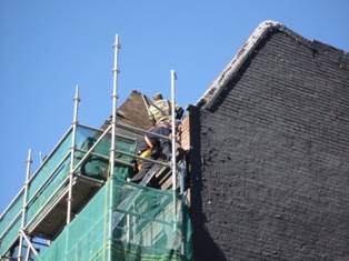 photo of masonry repair on paprapet wall in downtown Toronto Ontario shows scaffolding set up on commercial buidling 